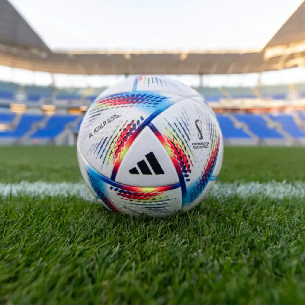 Colorful soccer ball FIFA worldcup on a grass field with stadium seats in the background