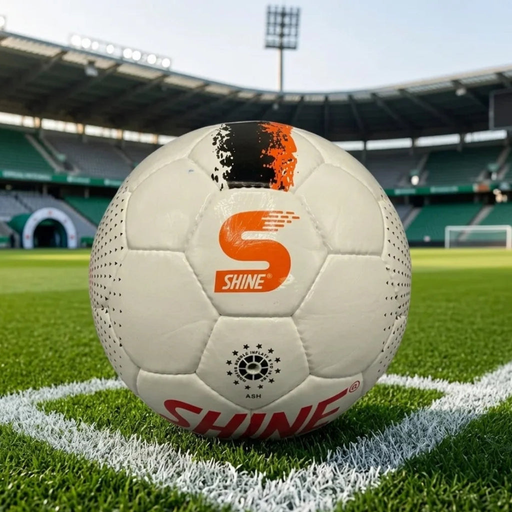 Soccer ball with 'Shine' branding on a grass field